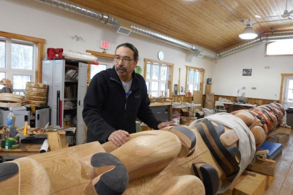Artist Keith Wolfe Smarch displays the Learning Centre totem in the carving shed. The goal of the carving shed is to preserve and carry on Carcross/Tagish First Nation stories and culture as well as teach people traditional skills (Photo: Samantha Dawson)