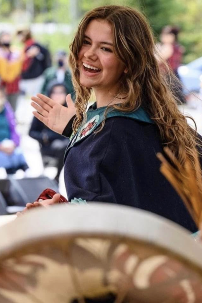 Woman with long hair dancing with drum in the foreground