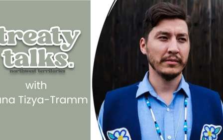 Dana Tizya-Tramm wearing blue vest with beaded flowers and logo of Treaty Talks NWT