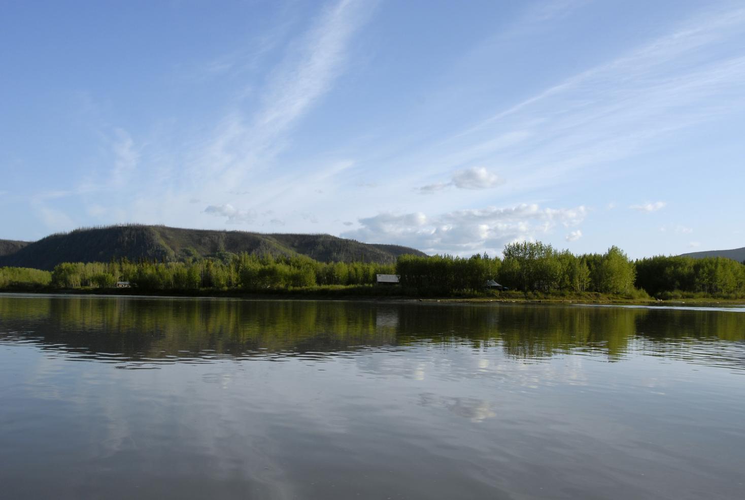 A horizon shot with water in the foreground, sky above, and mountainous land in the middle.