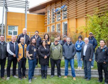 Yukon First Nations and Yukon government leaders stand in front of the Dänojà Zho Cultural Centre in Dawson.